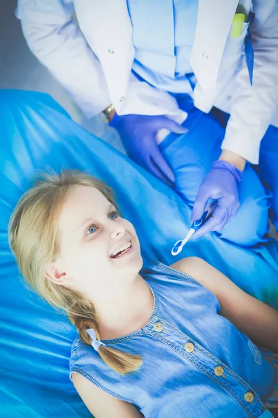 Niña sentada en el consultorio de dentistas. —  Fotos de Stock