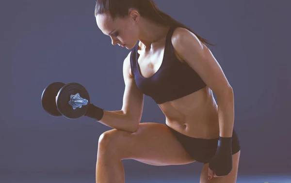 Muscular young woman standing on gray background. Muscular young woman. beautiful girl pumps muscles — Stock Photo, Image