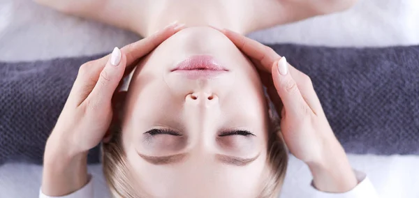 Mujer joven acostada en una mesa de masaje, relajándose con los ojos cerrados. Una mujer. Salón de spa — Foto de Stock