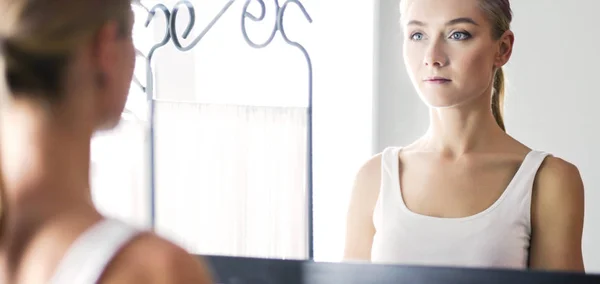 Rostro de joven hermosa mujer sana y la reflexión en el espejo — Foto de Stock