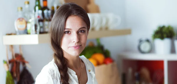 Mujer joven de pie cerca de escritorio en la cocina. Mujer joven . —  Fotos de Stock