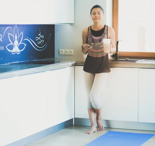 Retrato de una hermosa mujer deportiva usando un teléfono inteligente. Una mujer. Yoga. Deporte — Foto de Stock