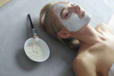 Yüz maskesi. Güzel genç kız Spa, makyajcısı kadın yüz maskesi uygulama.