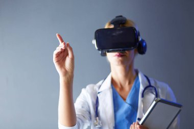 Sanal gerçeklik gözlüğü takan kadın doktor beyaz arka planda izole edilmiş..