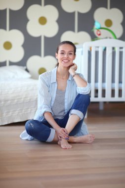 Genç kadın lotus pozisyonunda evde Yoga yapıyor. Genç kadın yoga yaparken.