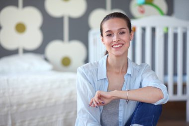 Çocuk karyolası yakın katta oturan bir genç bayan. Genç anne.