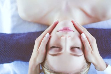 Masaj masasında uzanmış gözleri kapalı rahatlayan genç bir kadın. - Kadın. Spa salonu