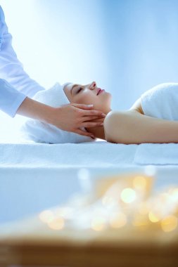 Masaj masasında uzanmış gözleri kapalı rahatlayan genç bir kadın. - Kadın. Spa salonu