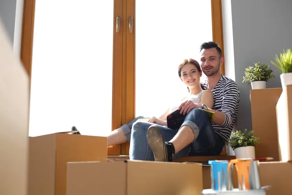 Par som flyttar i huset sitter på fönsterbrädan. Par — Stockfoto