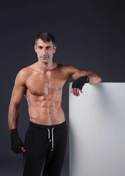 Musculoso hombre sosteniendo en blanco . —  Fotos de Stock