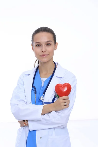 Positive female doctor standing with stethoscope and red heart symbol isolated. Woman doctor — Stock Photo, Image