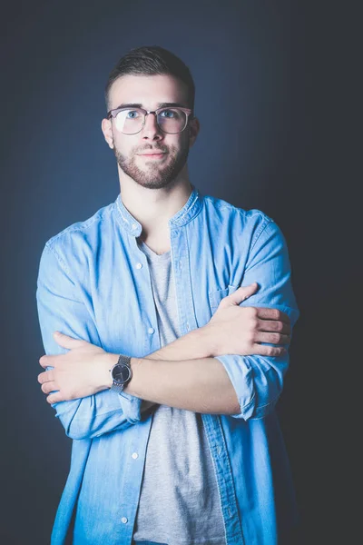 Retrato de un hombre casual feliz de pie aislado sobre un fondo oscuro. Hombre guapo posando . — Foto de Stock