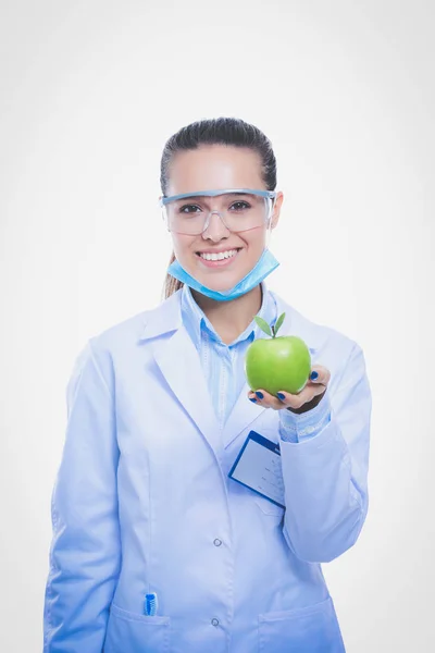 Врач-дантист женщина держит в руке зеленое свежее яблоко и зубную щетку. Врачи-дантисты. Женщины-врачи — стоковое фото