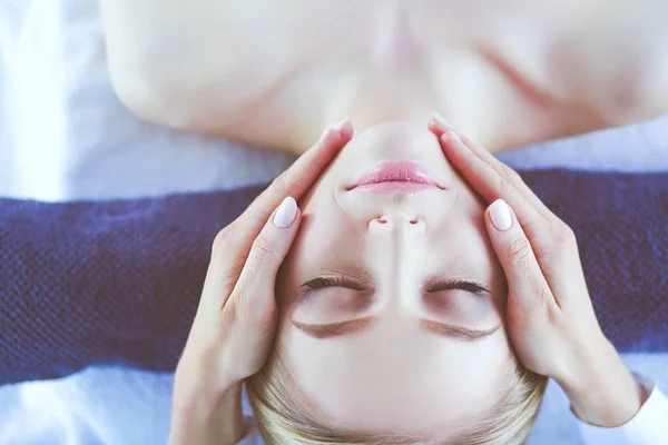 Jonge vrouw liggend op een massagetafel, ontspannend met gesloten ogen. Vrouw. Kuuroord — Stockfoto