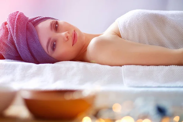 Young woman lying on a massage table,relaxing with eyes closed. Woman. Spa salon — Stock Photo, Image