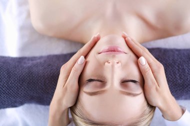 Masaj masasında uzanmış gözleri kapalı rahatlayan genç bir kadın. - Kadın. Spa salonu