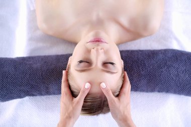 Masaj masasında uzanmış gözleri kapalı rahatlayan genç bir kadın. - Kadın. Spa salonu