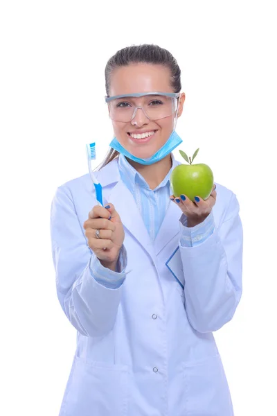 Diş hekimi kadın elinde yeşil elma ve diş fırçası tutuyor. Dişçi doktorlar. Kadın doktorlar — Stok fotoğraf