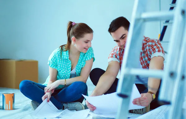 Pareja joven sentada en el suelo y calculando sobre sus ahorros. Pareja joven — Foto de Stock