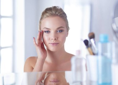 Genç güzel kadın ayna, Masa başında oturan yakınındaki makyaj yapma