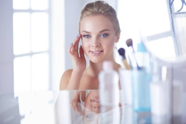 Genç güzel kadın ayna, Masa başında oturan yakınındaki makyaj yapma