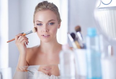 Genç güzel kadın ayna, Masa başında oturan yakınındaki makyaj yapma