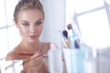 Genç güzel kadın ayna, Masa başında oturan yakınındaki makyaj yapma