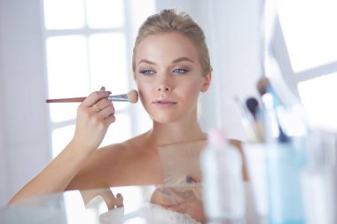 Genç güzel kadın ayna, Masa başında oturan yakınındaki makyaj yapma