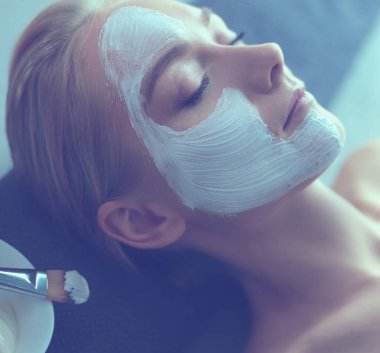 Yüz maskesi. Güzel genç kız Spa, makyajcısı kadın yüz maskesi uygulama.