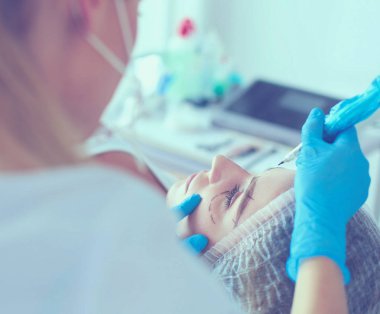 Kaşlar için kalıcı makyaj. Güzellik salonunda kalın kaşlı güzel bir kadın..