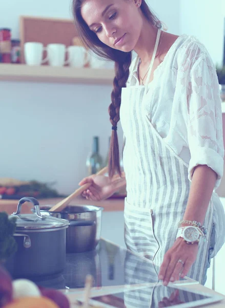 Cooking woman in kitchen with wooden spoon. Cooking woman