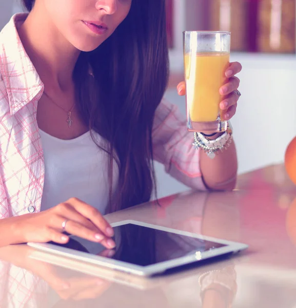 Uma jovem na cozinha, a usar o ipad. Jovem mulher — Fotografia de Stock