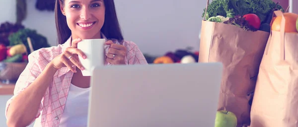 Lächelnde Frau beim Online-Shopping mit Tablet und Kreditkarte in der Küche. Lächelnde Frau — Stockfoto