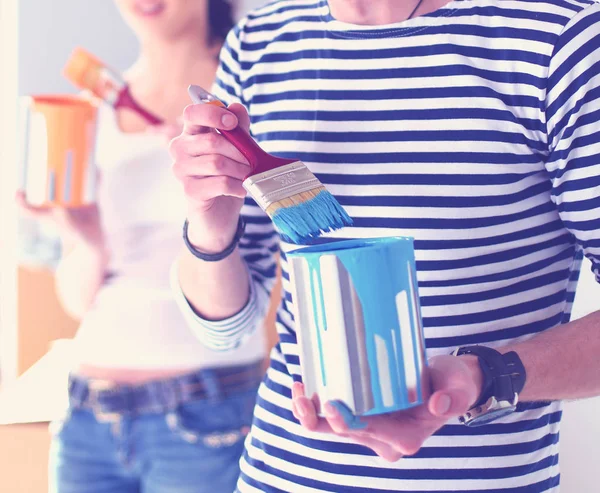 Portrait de jeune couple souriant heureux peignant mur intérieur de la maison neuve. jeune couple — Photo