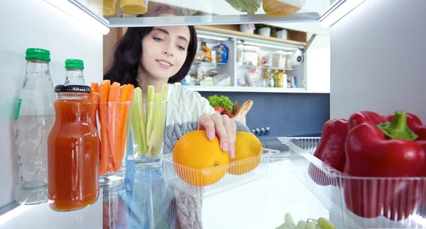 Portrait of female standing near open fridge full of healthy food, vegetables and fruits. Portrait of female — Stock Photo, Image