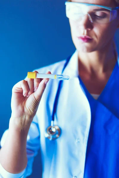 Female medical or research scientist or doctor using looking at a test tube of clear solution in a lab or laboratory. — Stock Photo, Image