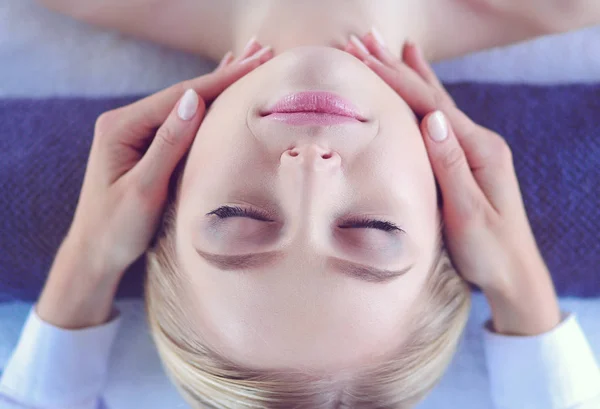 Mujer joven acostada en una mesa de masaje, relajándose con los ojos cerrados. Una mujer. Salón de spa — Foto de Stock