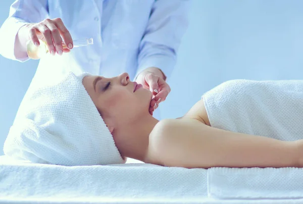 Jovem deitada em uma mesa de massagem, relaxando com os olhos fechados. Mulher. Salão de Spa — Fotografia de Stock