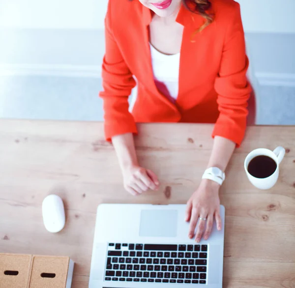 Mulher atraente sentada na mesa no escritório, trabalhando com computador portátil — Fotografia de Stock