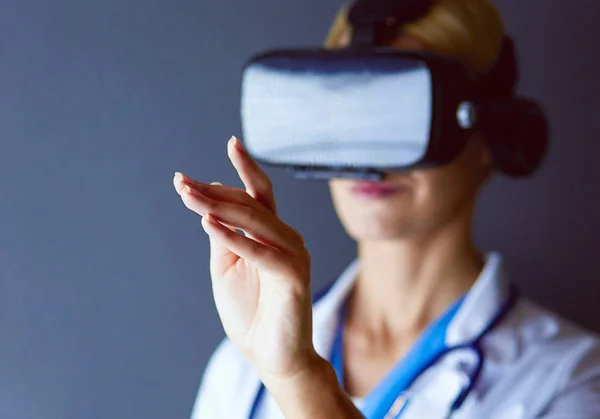 Médecin féminin portant des lunettes de réalité virtuelle isolées sur fond blanc. — Photo