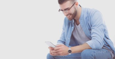 Sandalyede oturan ve cep telefonuyla genç adam. Startupper. Genç girişimci.