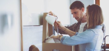 Genç bir çift yeni evde büyük karton kutu taşıyan. Ev taşıma. Genç Çift