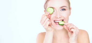 Beyaz zemin üzerine salatalık dilimleri ile genç güzel kadın