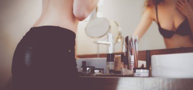 Genç kadın kendini banyo ayna arıyor.