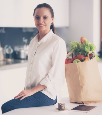 Giderleri planlama ve mutfağını faturalarında ödeme genç kadın.