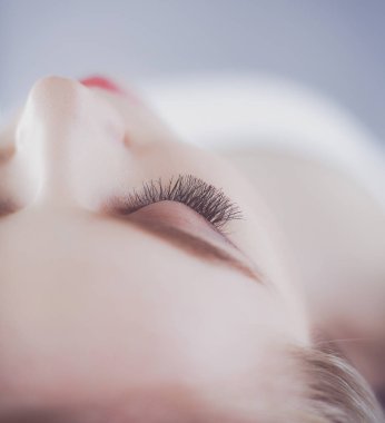 Masaj masasında uzanmış gözleri kapalı rahatlayan genç bir kadın. - Kadın. Spa salonu