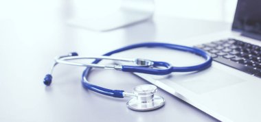 Tıbbi ekipman: Beyaz arka planda mavi steteskop ve tablet. Tıbbi ekipman