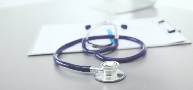 Tıbbi ekipman: Beyaz arka planda mavi steteskop ve tablet. Tıbbi ekipman