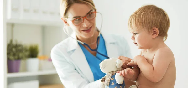 La dottoressa sta ascoltando un bambino con uno stetoscopio in clinica. — Foto Stock