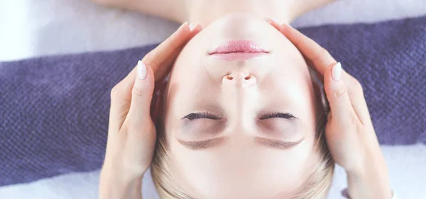 Mujer joven acostada en una mesa de masaje, relajándose con los ojos cerrados. Una mujer. Salón de spa — Foto de Stock